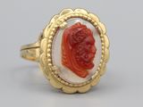 an image of a gold ring with a red cameo in the center