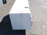 a white refrigerator sitting on the side of the road