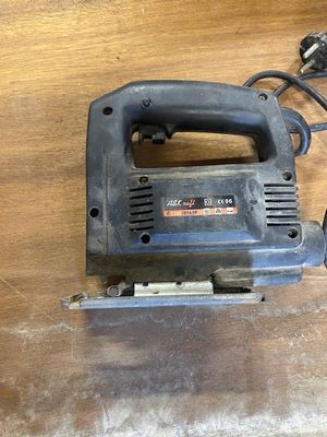 an electric jig saw sitting on top of a wooden table