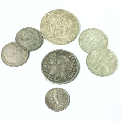plusieurs pièces de monnaie sont disposées en cercle sur une surface blanche