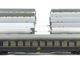 several model trains are lined up in a row on a white surface