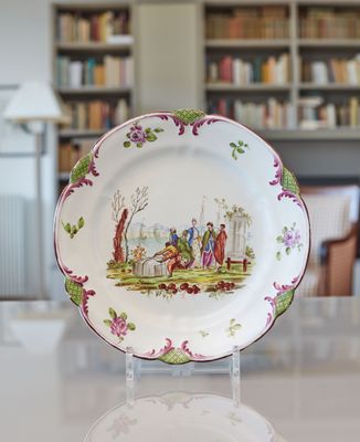 une assiette sur laquelle figure une image représentant des personnes, posée sur une table