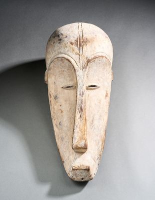 une image d'un masque en bois accroché au mur
