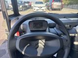 a steering wheel and dashboard of a vehicle in a parking lot