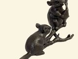 a statue of a mouse and a mouse on a tree branch
