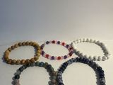 un lot de cinq bracelets posés sur une surface blanche
