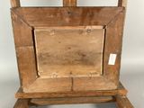 an old wooden easel with a wooden seat and a wooden frame