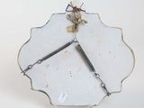 a clock that is sitting on a stand on a white surface