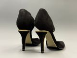 une paire de chaussures noires à talons hauts sur une surface blanche