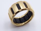 a close up of a gold and black ring on a white surface
