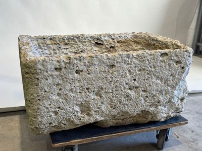 un gros bloc de pierre posé sur un socle en bois