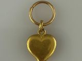 un pendentif en forme de cœur doré sur fond blanc