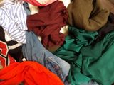 a pile of clothes that is sitting on a bed