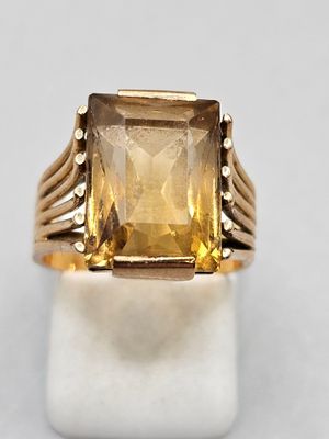 un gros plan d'une bague en or sertie d'une citrine facettée