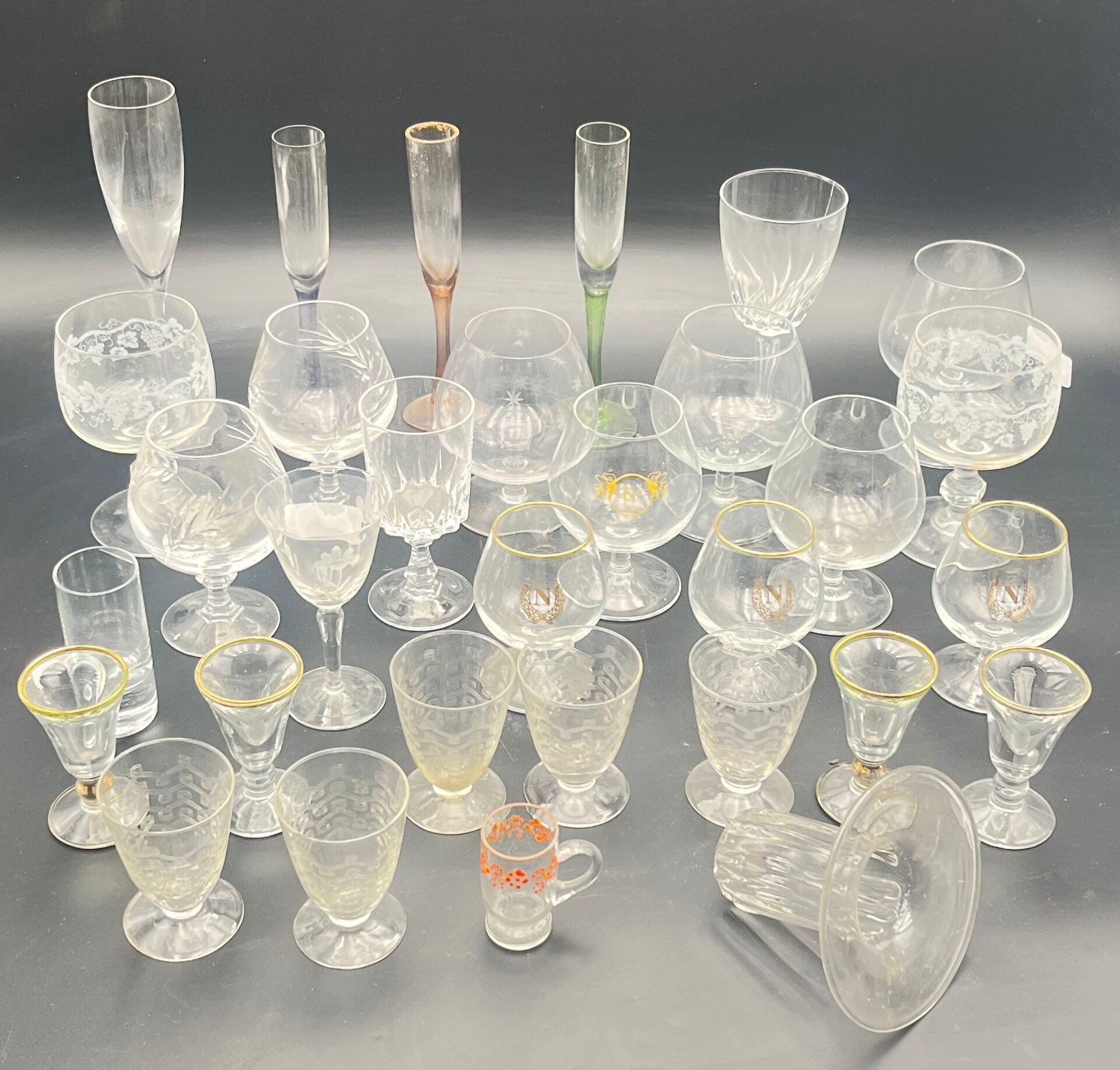 Suite de trente verres en verre et cristal dont des verres à vin, des verres à cognac, des verres à digestif. (fêles,...