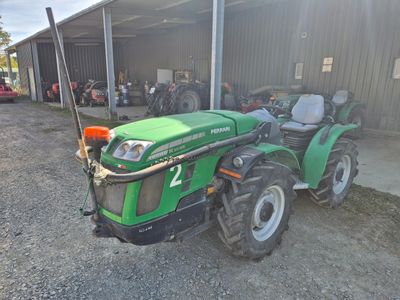 un tracteur vert garé devant un bâtiment