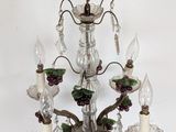 a chandelier that has a bunch of candles and grapes on it