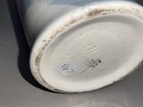a white vase sitting on a table with a sticker on it