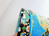une personne tenant un vase bleu et jaune à la main