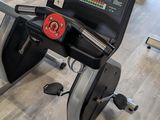 someone is using a stationary exercise bike in a gym