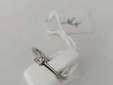 a close up of a ring on a white surface with a tag