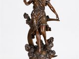 une statue antique en bronze représentant une femme avec un oiseau sur l'épaule