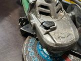 Quelqu'un utilise une meuleuse pour découper un morceau de métal posé sur une table.