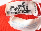 a label that says hermes paris on the back of a red teddy bear