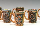 six mugs with designs on them are lined up in a row