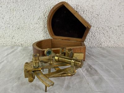 une petite boîte en bois contenant un assortiment d'objets en laiton