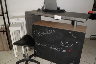 un tableau noir posé sur le comptoir, avec un ordinateur portable dessus