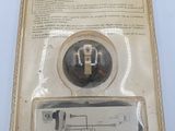 an image of a package with a button on it that is in the packaging