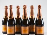 six bottles of champagne are lined up in a row