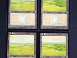 four cards with a picture of a green field and a sun on them