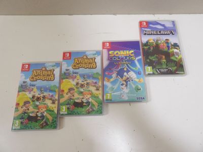 four nintendo wii games sitting on top of a white table