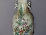 a vase with a painting on it sitting on a table