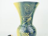 a blue vase with a drawing on it next to a mouse
