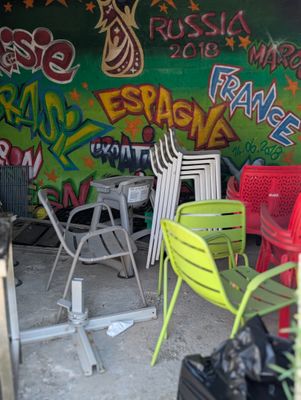 de nombreuses chaises et tables dans une pièce dont les murs sont couverts de graffitis