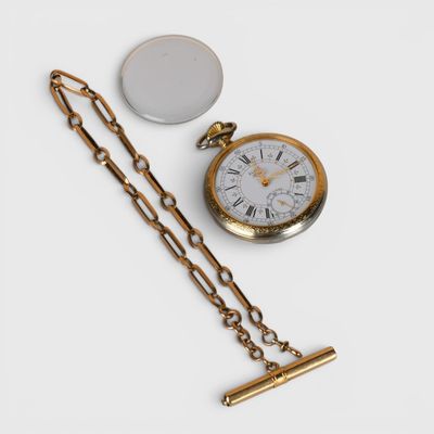 une montre de poche en or et une chaîne posées sur une surface blanche