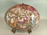 a decorative plate with a painting on it on a stand