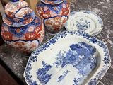plusieurs assiettes et bols bleus et blancs posés sur une table, à côté de boîtes