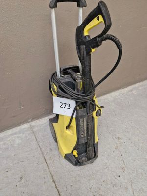 une borne électrique jaune et noire posée au sol près d'un mur