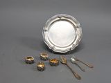 un plateau en argent avec des cuillères, des fourchettes et une assiette en argent