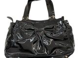 une image représentant un sac à main noir orné d'un nœud