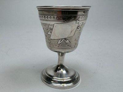 a silver goblet sitting on a table with a white background