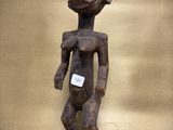 a wooden statue of a person with a tag on it ' s chest