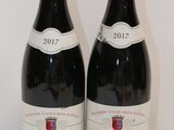 deux bouteilles de vin rouge posées sur une table l'une à côté de l'autre