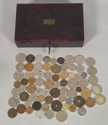 a small wooden box filled with coins on a white surface