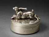 une boîte en argent sur laquelle est représenté un lapin