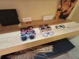 two pairs of sunglasses on a shelf in a room
